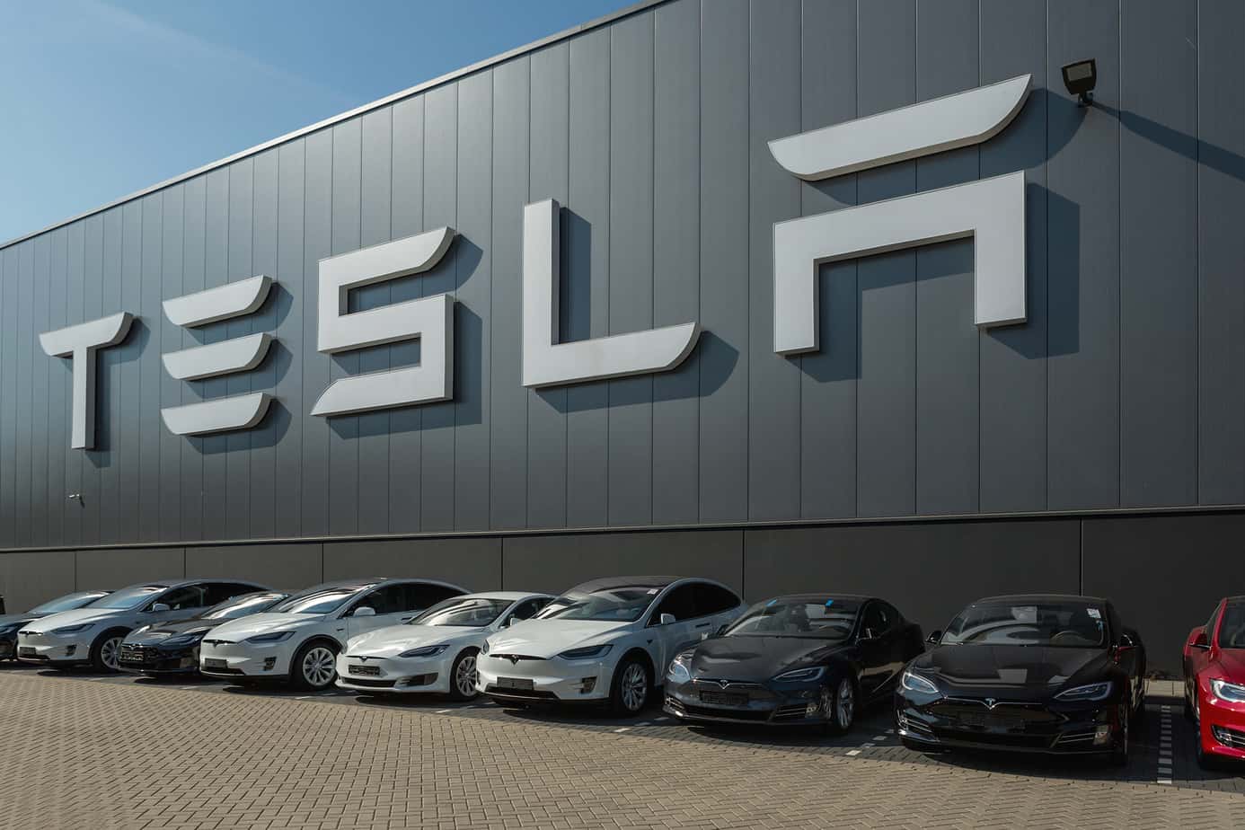 tesla cars in front of tesla building