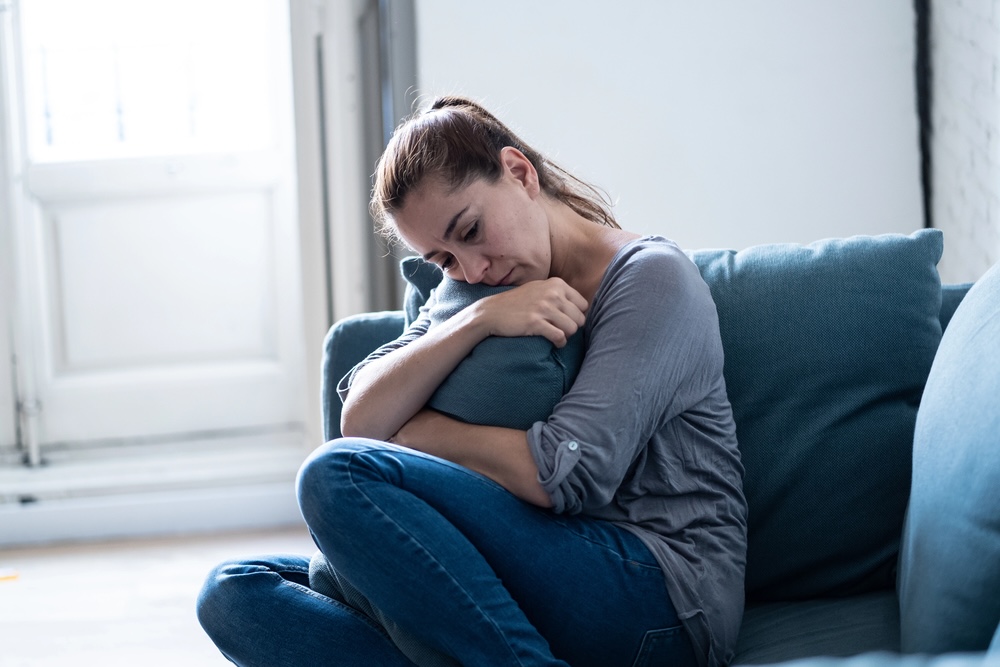 woman on couch in pain
